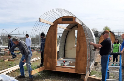 People working together to build a shelter for the homeless.