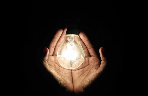 Hands holding a lite light bulb