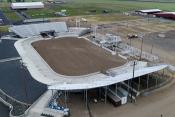 Well-manicured rodeo arena with stadium seating on the three sides