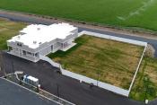 Fenced grass area attached to large concession stand