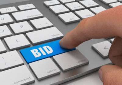 Finger pushing the word "BID" on a keyboard