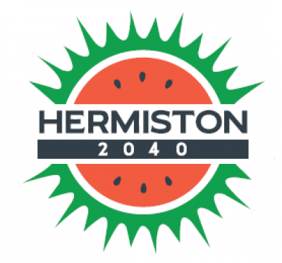 Combination of a watermelon and sunshine with the words HERMISTON 2040 in the middle