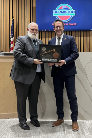Doug Primmer hands a commemorative plaque to Dave Drotzmann at Hermiston City Hall.