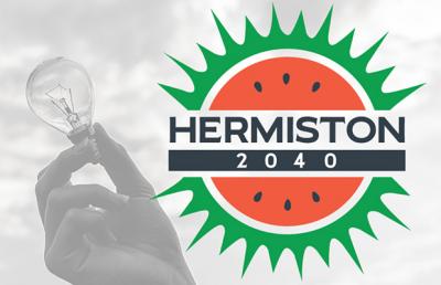 Hand holds up a light bulb next to Hermiston 2040 logo