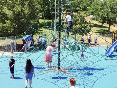 Children play on Funland Playground climbing structure.